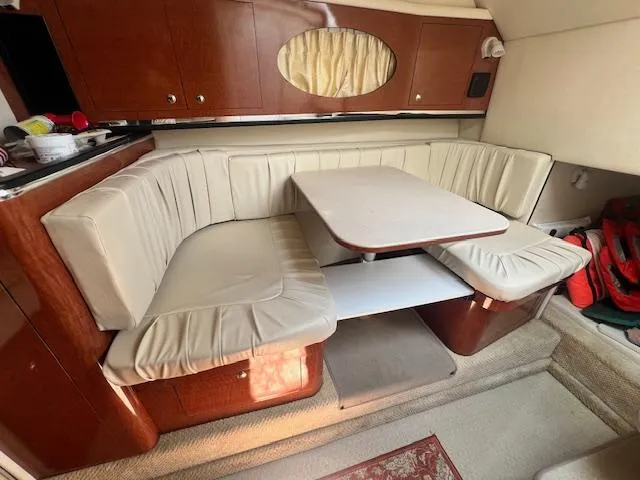 Slide: The Image of 2003 Sea Ray 290 Amberjack cabin with beige seating and wooden cabinetry. - 16