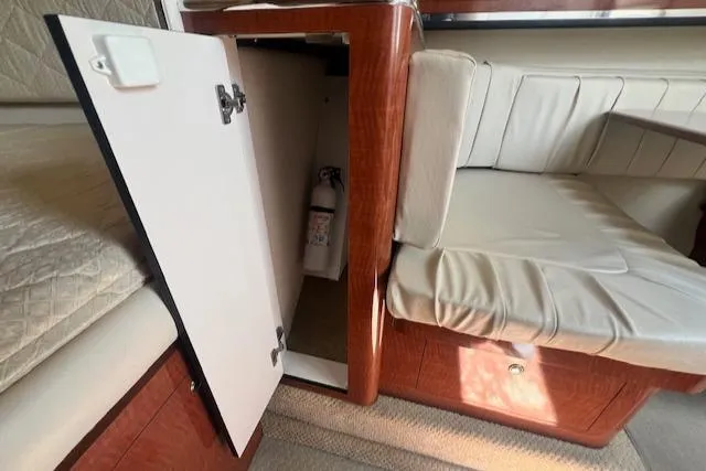Slide: The Image of 2003 Sea Ray 290 Amberjack interior with open cabinet and fire extinguisher. - 20