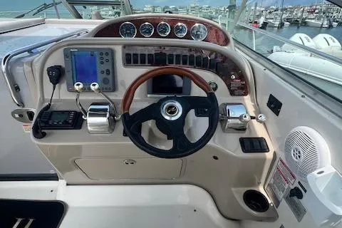 Slide: The Image of 2003 Sea Ray 290 Amberjack helm with gauges, steering wheel, and navigation equipment. - 3