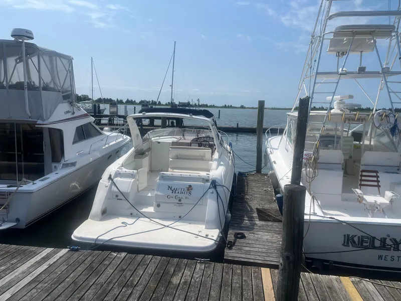 The Image of 2003 Regal 3260 Commodore yacht docked between two boats at a marina. - 0