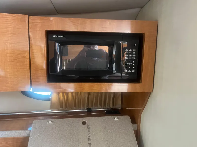 Slide: The Image of Microwave in 2003 Regal 3260 Commodore boat kitchen, wooden cabinetry. - 6