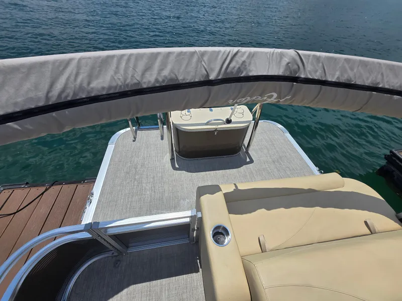 Slide: The Image of 2020 Avalon LSZ Cruise II boat with beige seating, docked on calm water. - 11