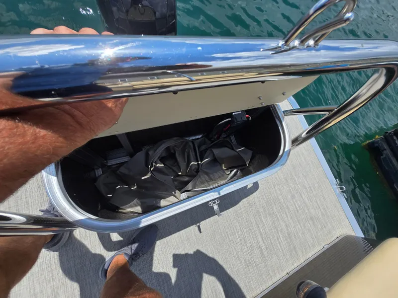 Slide: The Image of 2020 Avalon LSZ Cruise II boat storage compartment with railing, docked on water. - 12
