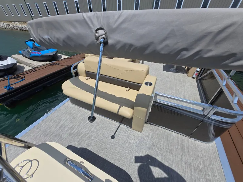 Slide: The Image of 2020 Avalon LSZ Cruise II pontoon boat with beige seating and covered canopy at dock. - 13