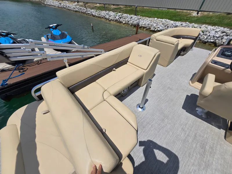 Slide: The Image of 2020 Avalon LSZ Cruise II pontoon boat with beige seating, docked near jet skis. - 15