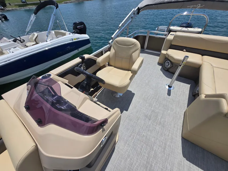 Slide: The Image of 2020 Avalon LSZ Cruise II pontoon boat interior with beige seating and steering console. - 9