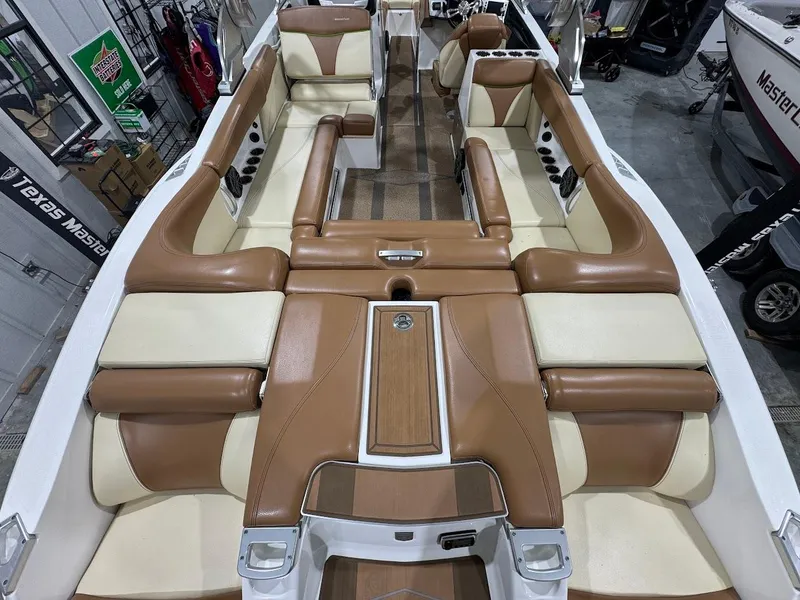 Slide: The Image of 2016 MasterCraft X26 boat interior with tan and cream seating, showcasing spacious and luxurious design. - 12