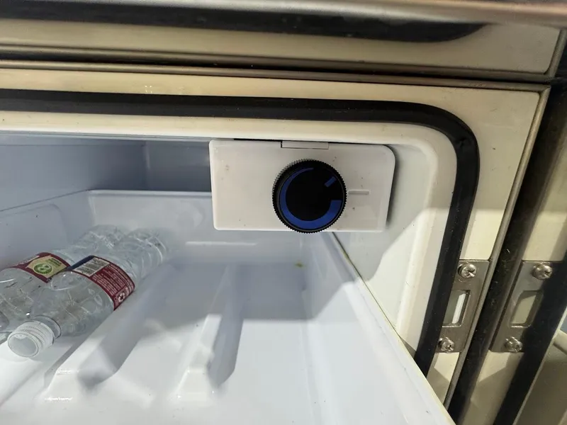 Slide: The Image of Refrigerator inside a 2016 MasterCraft X26 boat with water bottles and temperature control knob. - 23