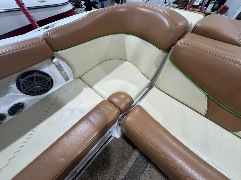 Slide: The Image of 2016 MasterCraft X26 boat interior with tan and cream seating, green accents, and speaker. - 26