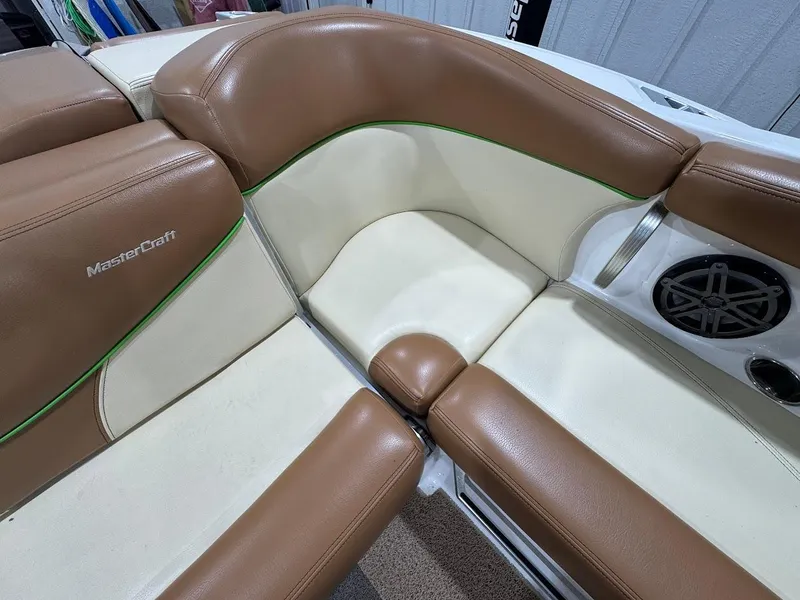 Slide: The Image of 2016 MasterCraft X26 boat interior with tan and cream seating, featuring a speaker. - 27
