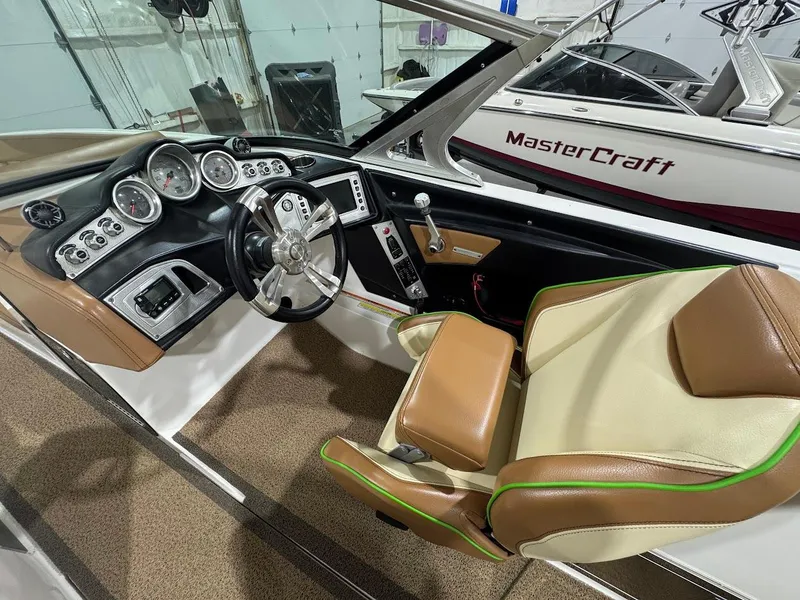 Slide: The Image of 2016 MasterCraft X26 boat interior with steering wheel and dashboard controls. - 28