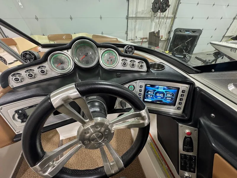Slide: The Image of 2016 MasterCraft X26 boat dashboard with steering wheel and digital display. - 30