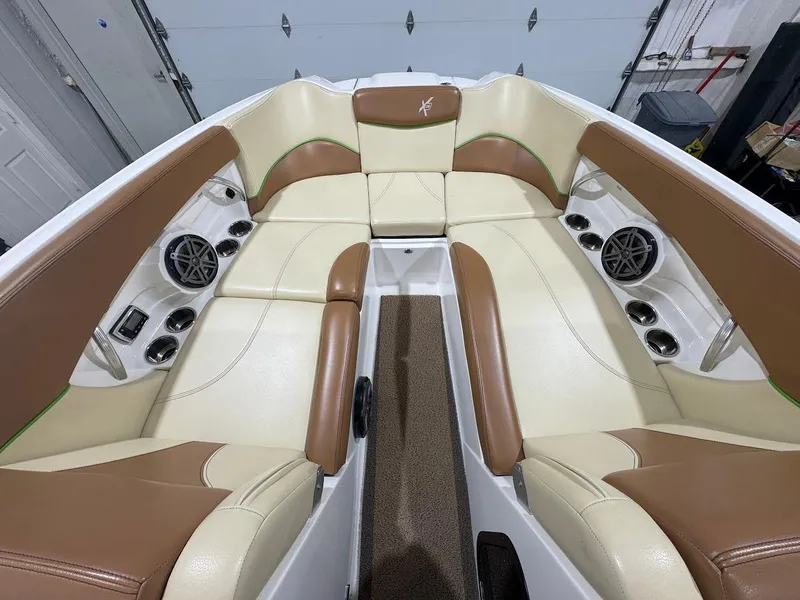 Slide: The Image of Luxurious 2016 MasterCraft X26 boat interior with tan and cream seating, featuring built-in speakers. - 32