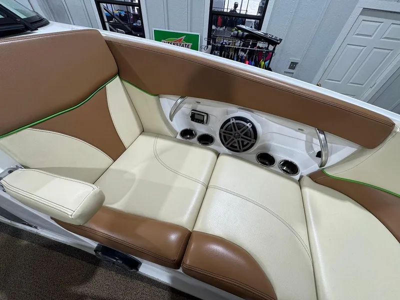 Slide: The Image of 2016 MasterCraft X26 boat interior with tan and cream seating, featuring built-in speakers. - 34