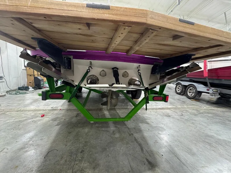 Slide: The Image of Rear view of a 2016 MasterCraft X26 boat on a green trailer in a garage. - 4