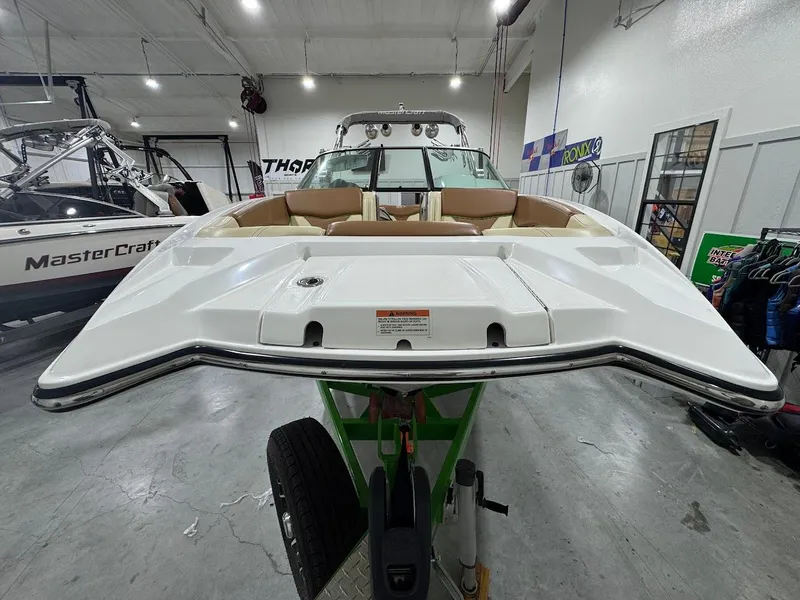 Slide: The Image of 2016 MasterCraft X26 boat displayed indoors, showcasing sleek design and spacious seating. - 8
