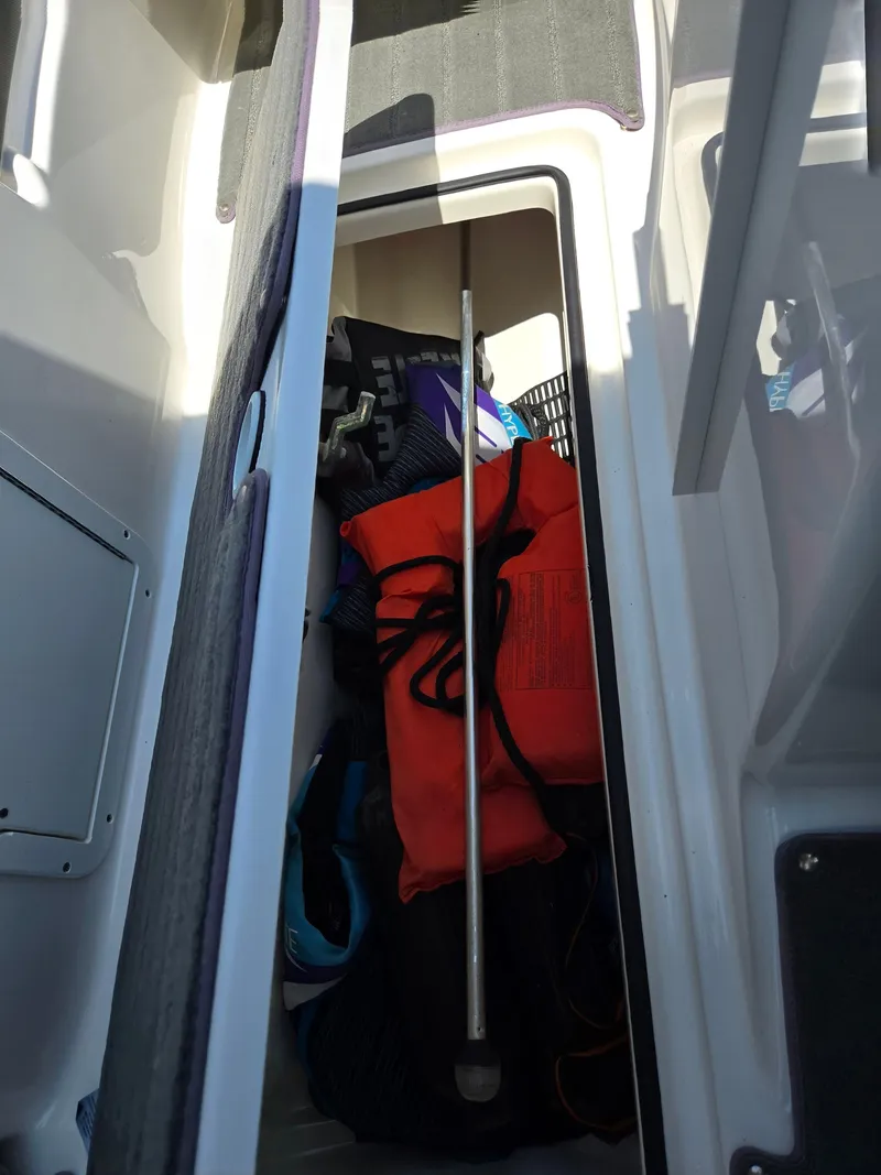 Slide: The Image of Storage compartment in a 2013 Yamaha Boats 212SS, containing life jacket and boating gear. - 15