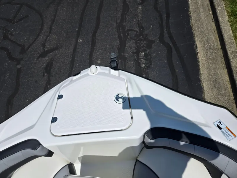 Slide: The Image of Bow of 2013 Yamaha Boats 212SS with storage compartment, parked on asphalt. - 17