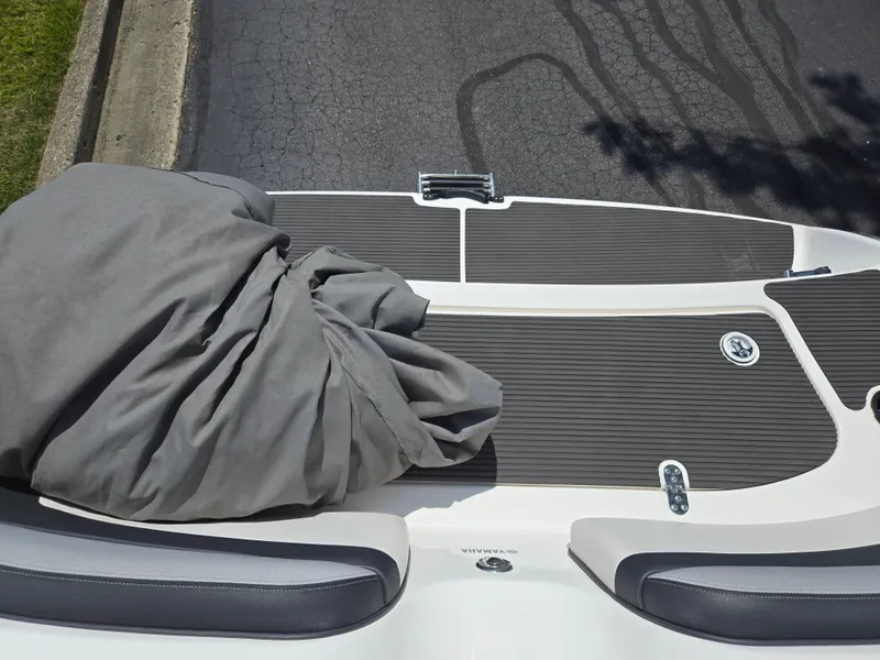 Slide: The Image of 2013 Yamaha Boats 212SS swim platform with gray cover, docked on asphalt. - 23