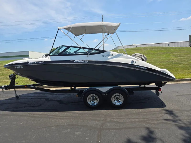 Slide: The Image of 2013 Yamaha Boats 212SS on trailer, black and white, with canopy, parked on asphalt. - 4