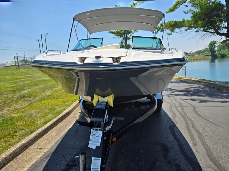 Slide: The Image of 2013 Yamaha Boats 212SS on trailer, parked near a lake under clear skies. - 6