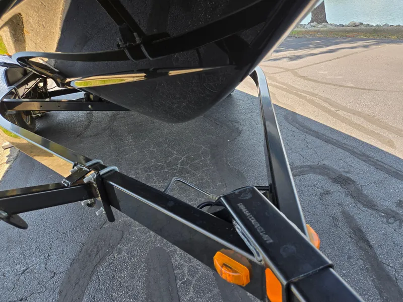 Slide: The Image of Trailer of a 2013 Yamaha Boats 212SS on a paved surface near water. - 7