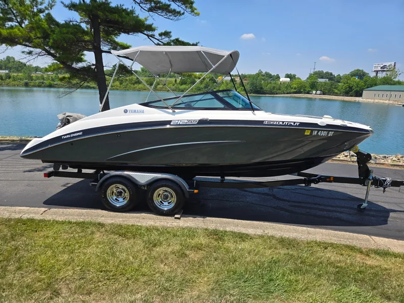 Slide: The Image of 2013 Yamaha Boats 212SS on trailer by a lake, under clear blue sky. - 9