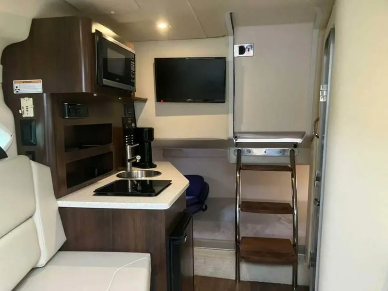 Slide: The Image of Interior of 2017 Regal 26 Express boat with kitchenette and seating area. - 11