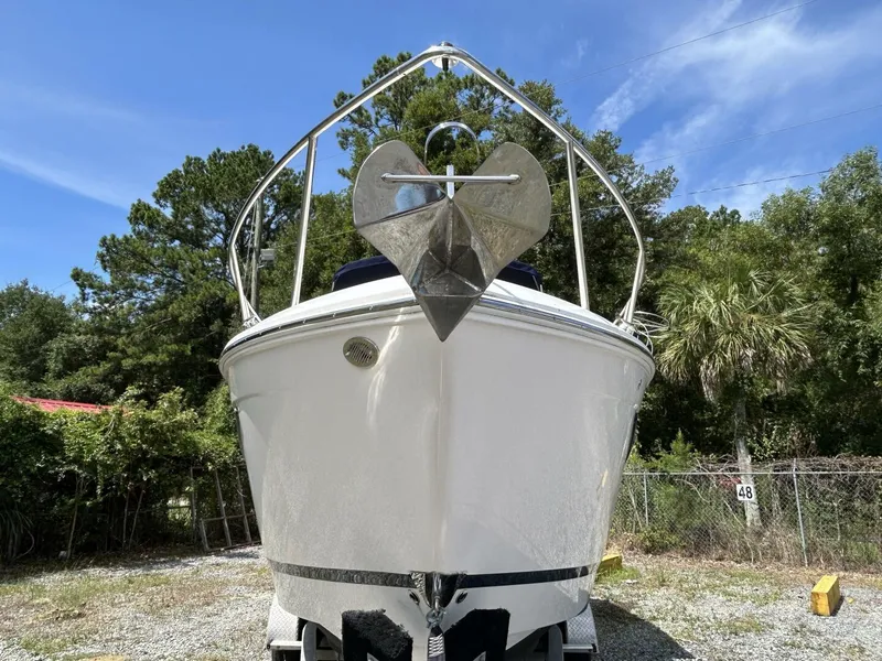 Slide: The Image of 2017 Regal 26 Express boat on land, surrounded by trees and blue sky. - 2