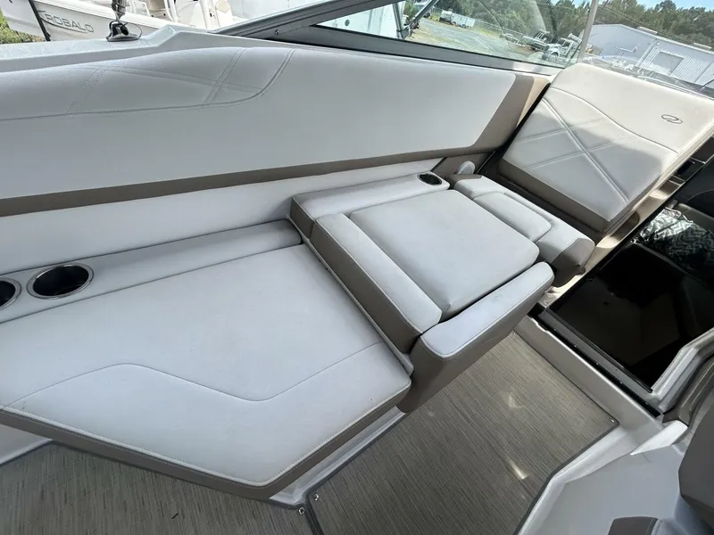 Slide: The Image of 2017 Regal 26 Express boat interior with white cushioned seating and cup holders. - 24