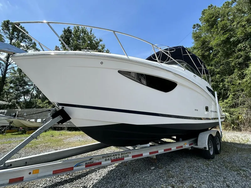 Slide: The Image of 2017 Regal 26 Express boat on trailer, parked outdoors under clear blue sky. - 3