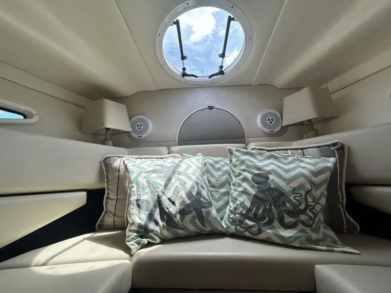 Slide: The Image of Interior of 2017 Regal 26 Express boat with decorative pillows and porthole view. - 41
