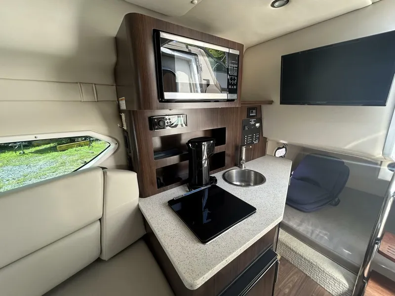 Slide: The Image of Interior of 2017 Regal 26 Express boat with kitchenette and seating area. - 47