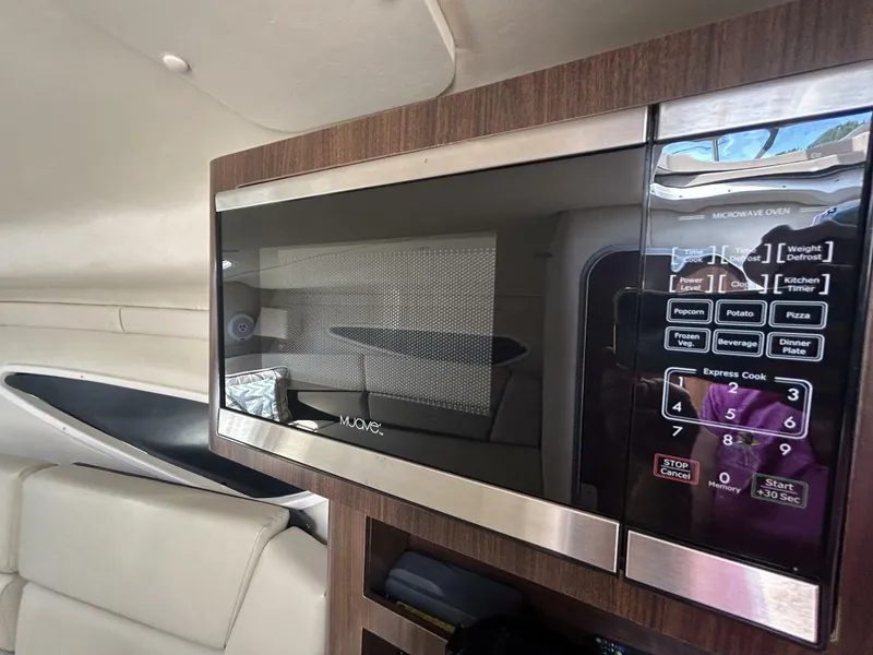 Slide: The Image of Microwave oven inside 2017 Regal 26 Express boat cabin, featuring digital controls. - 48