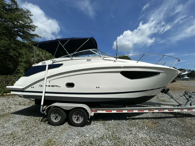 Slide: The Image of 2017 Regal 26 Express boat on trailer under clear blue sky. - 6