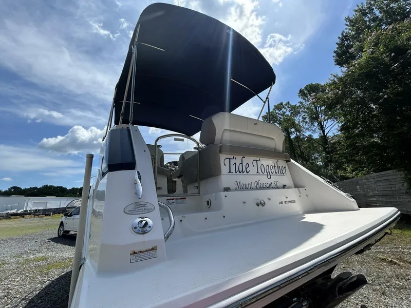 Slide: The Image of 2017 Regal 26 Express boat with canopy, named "Tide Together," parked outdoors. - 8