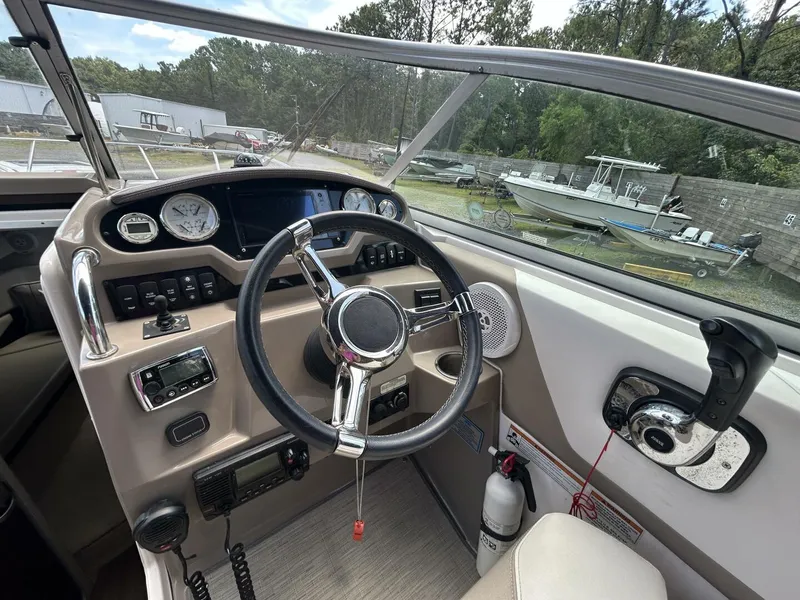 Slide: The Image of Cockpit of 2017 Regal 26 Express boat with steering wheel and control panel. - 9