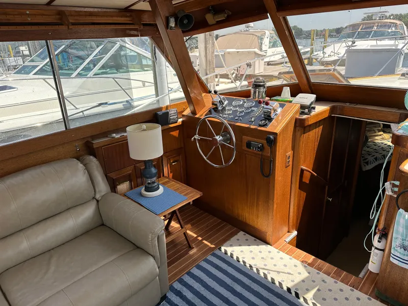 Slide: The Image of 1977 Egg Harbor 33 Sedan interior with helm, leather seating, and wooden accents. - 13
