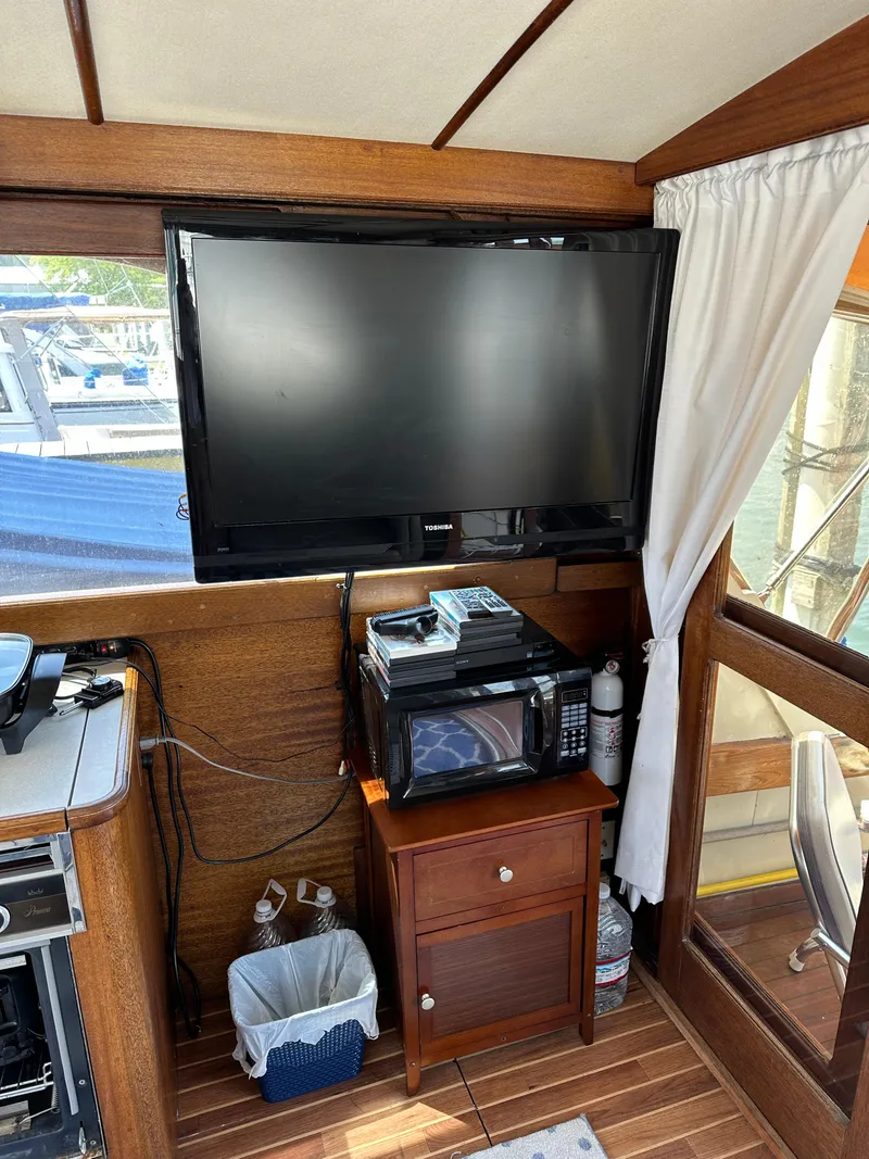 Slide: The Image of Interior of a 1977 Egg Harbor 33 Sedan with TV, microwave, and wooden cabinetry. - 17