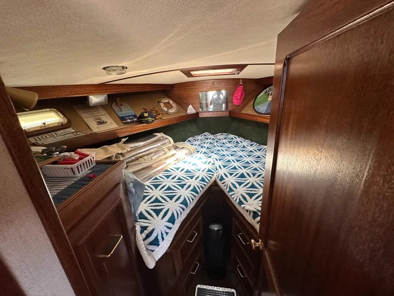 Slide: The Image of Cozy cabin interior of a 1977 Egg Harbor 33 Sedan with patterned bedding and wooden accents. - 18