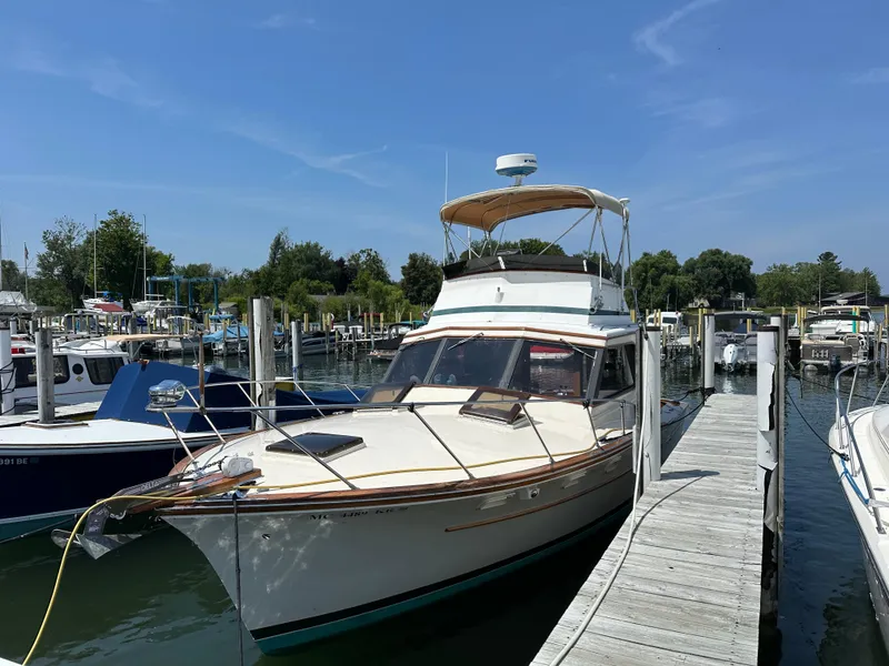 Slide: The Image of 1977 Egg Harbor 33 Sedan docked at a marina under a clear blue sky. - 2