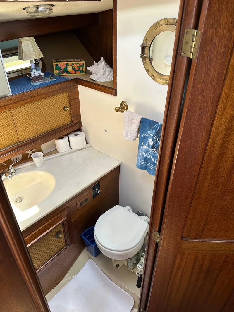Slide: The Image of 1977 Egg Harbor 33 Sedan bathroom with sink, toilet, and nautical decor. - 22