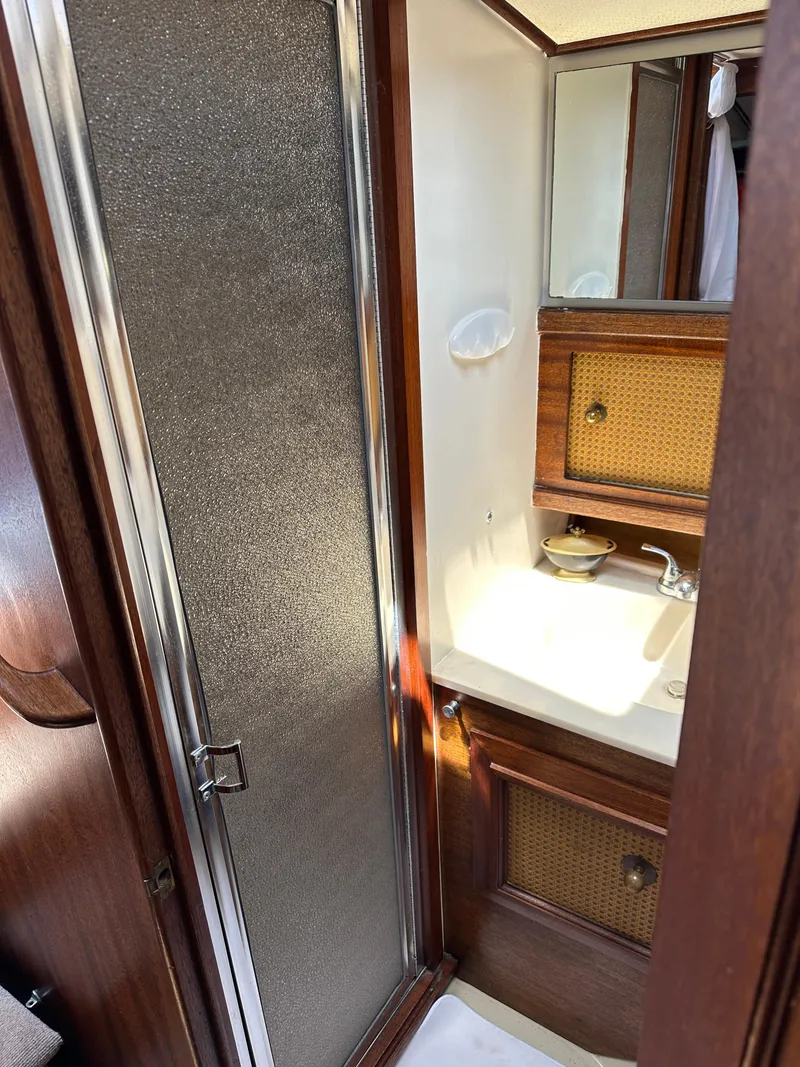Slide: The Image of 1977 Egg Harbor 33 Sedan bathroom with wood accents and compact sink area. - 23