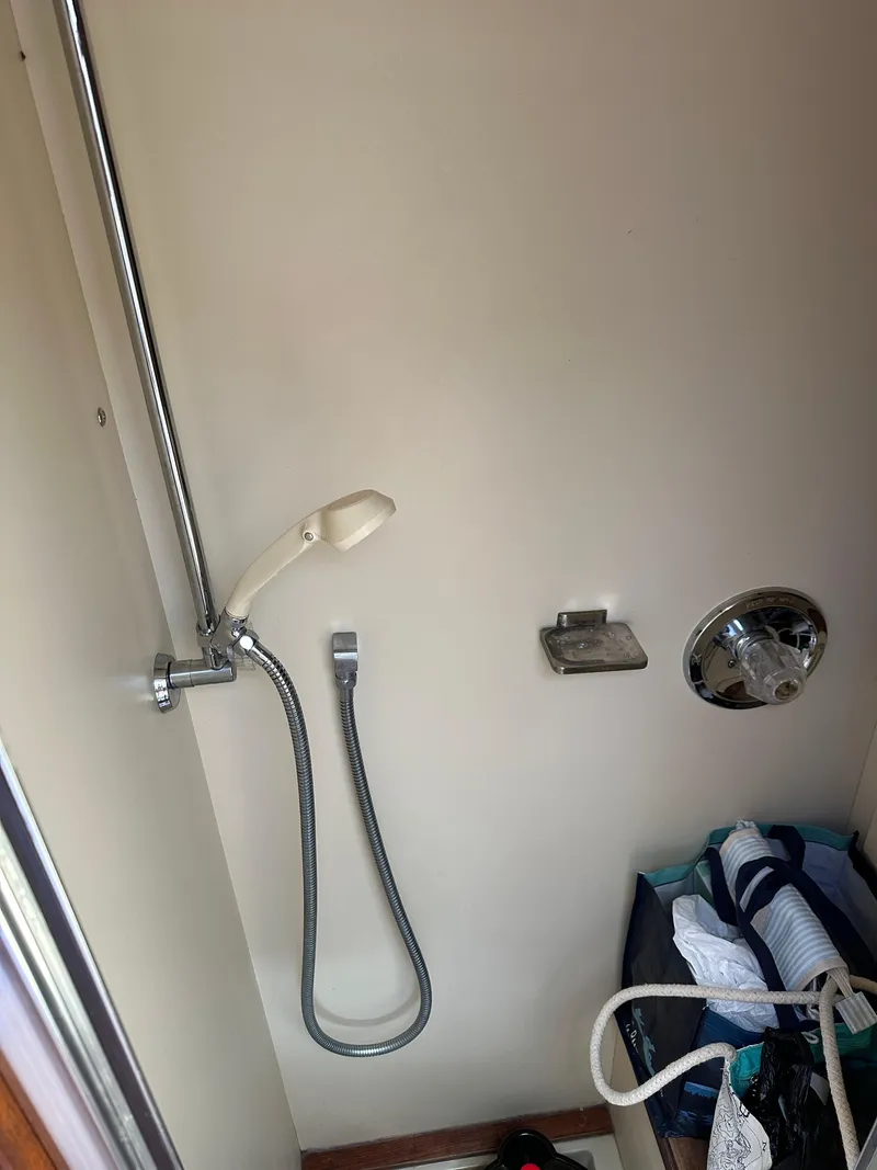 Slide: The Image of 1977 Egg Harbor 33 Sedan shower area with handheld showerhead and storage bag. - 24