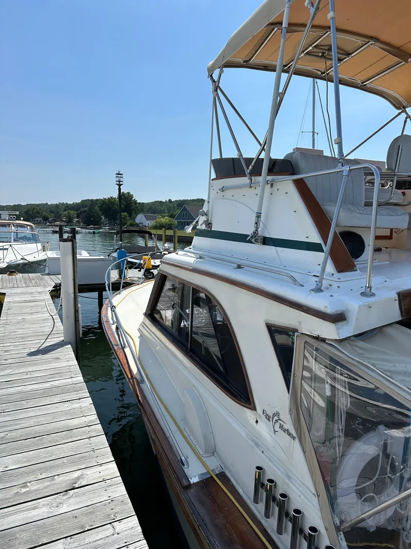 Slide: The Image of 1977 Egg Harbor 33 Sedan docked at a marina under clear blue skies. - 3
