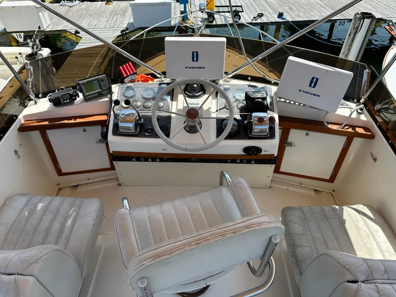 Slide: The Image of 1977 Egg Harbor 33 Sedan boat cockpit with steering wheel, navigation equipment, and seating. - 31