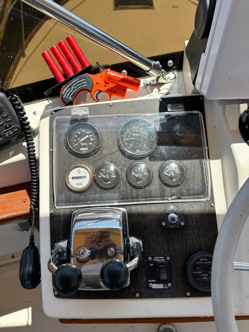 Slide: The Image of 1977 Egg Harbor 33 Sedan control panel with gauges, throttle, and safety equipment. - 33