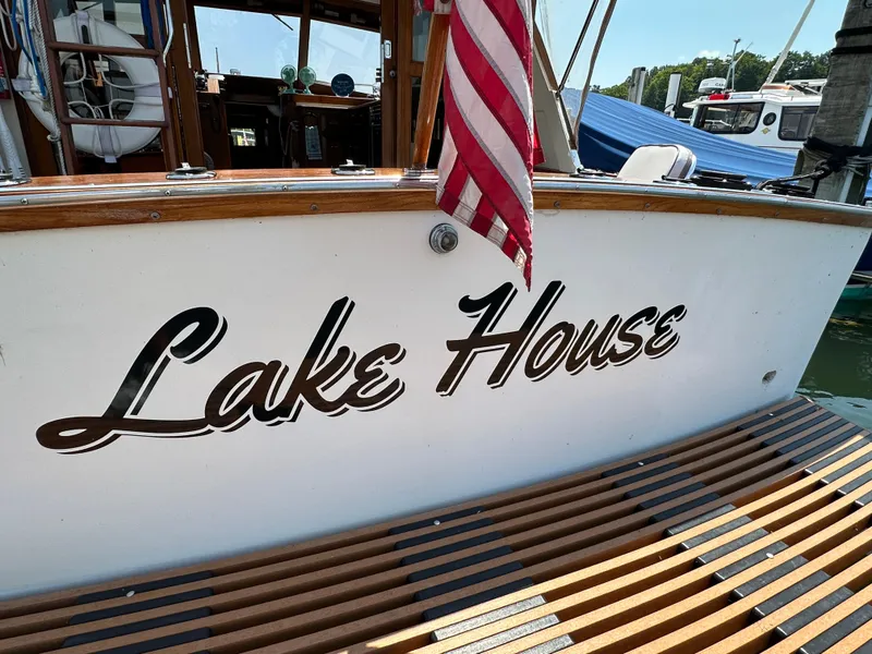 Slide: The Image of 1977 Egg Harbor 33 Sedan boat named "Lake House" docked with American flag. - 39