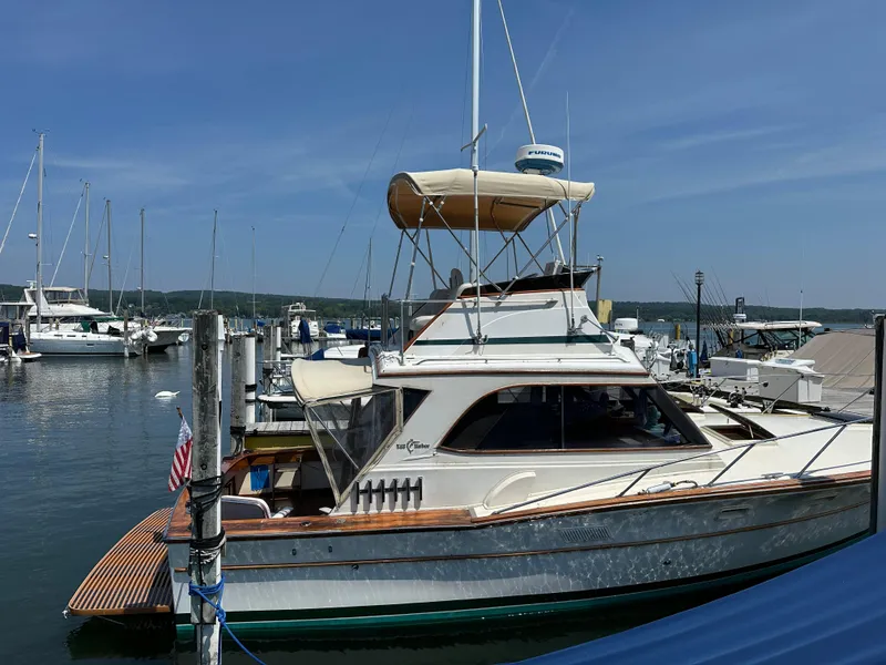 Slide: The Image of 1977 Egg Harbor 33 Sedan yacht docked at a marina under clear blue skies. - 4