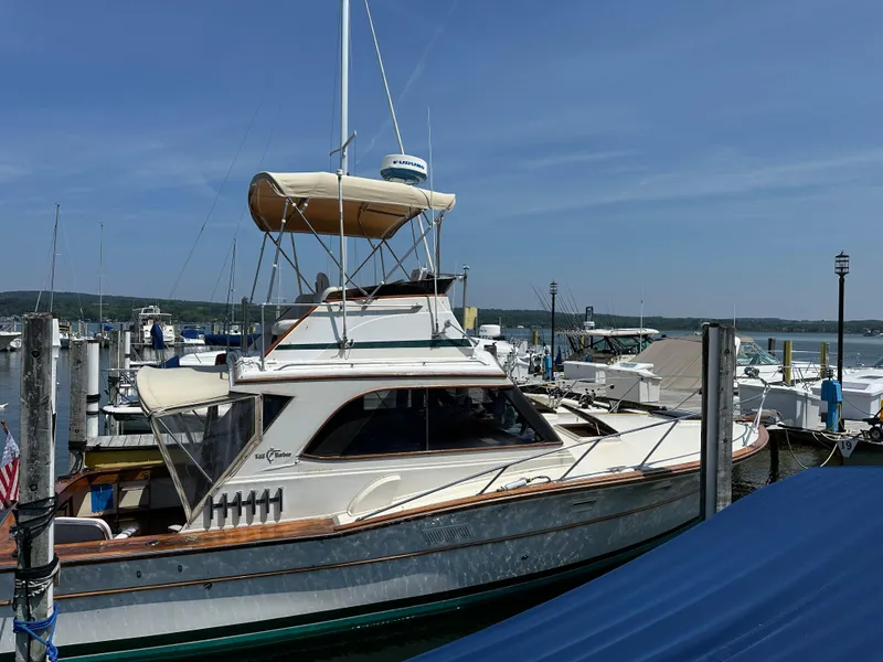 Slide: The Image of 1977 Egg Harbor 33 Sedan boat docked at a marina under clear blue skies. - 5